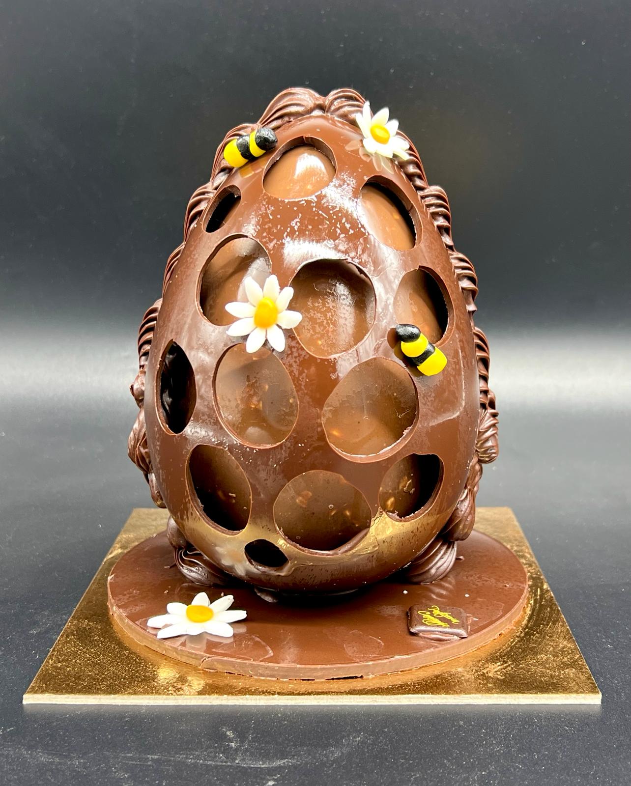 Uovo di cioccolato traforato decorato con api e margherite, pasticceria Caravaggio Pasqua 2024
