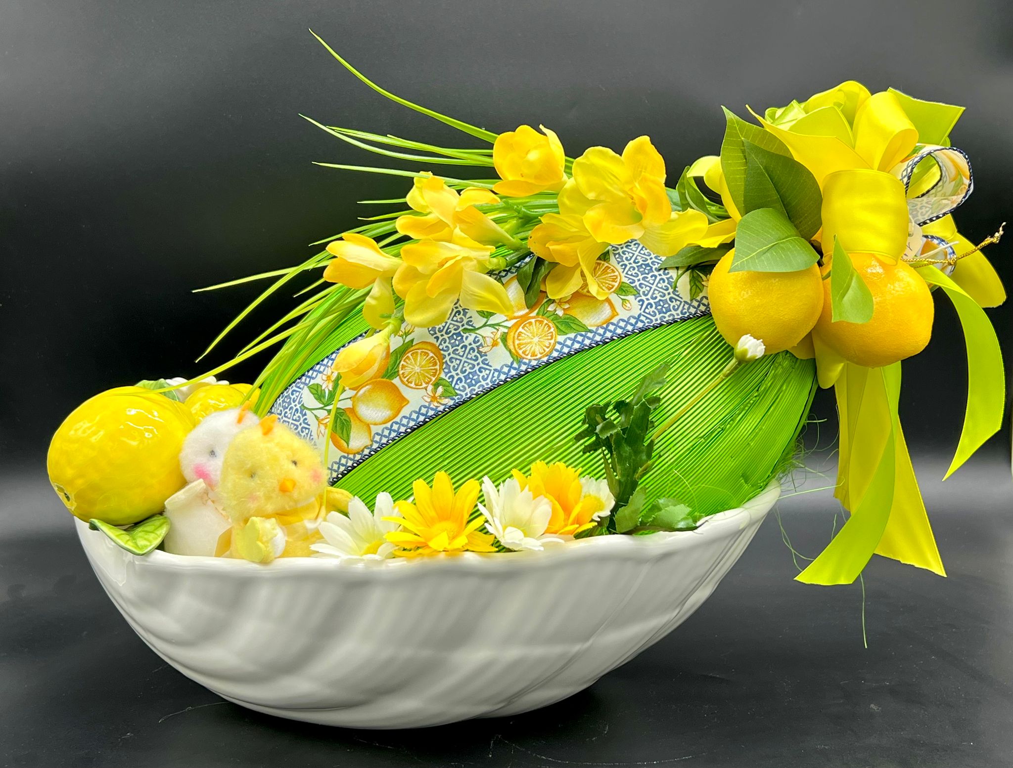 Cestino bianco decorato con limoni, pulcino e fiori gialli, pasticceria Caravaggio Pasqua 2024