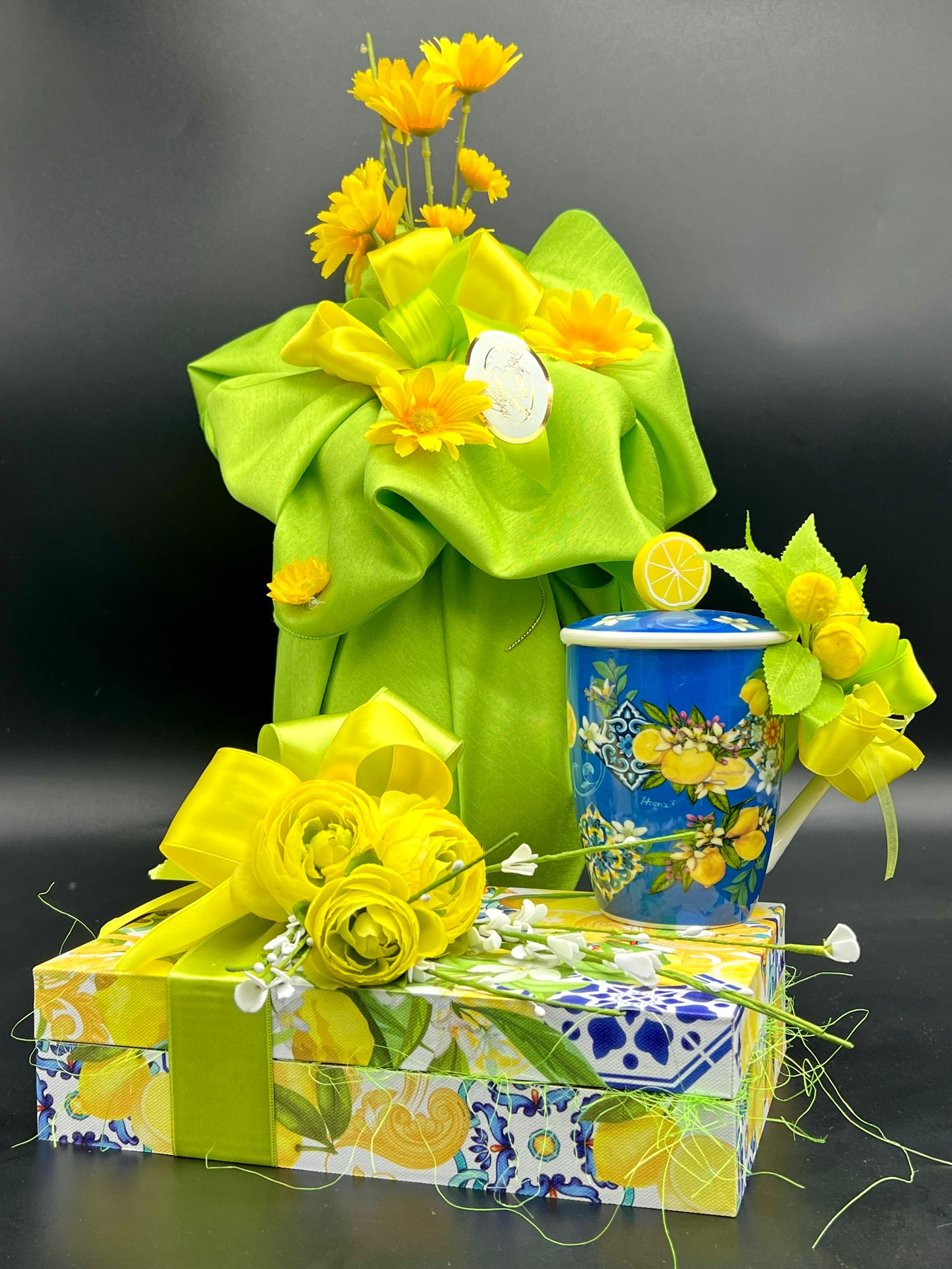 Composizione decorativa verde con limoni e scatola regalo a tema Pasqua, pasticceria Caravaggio 2024