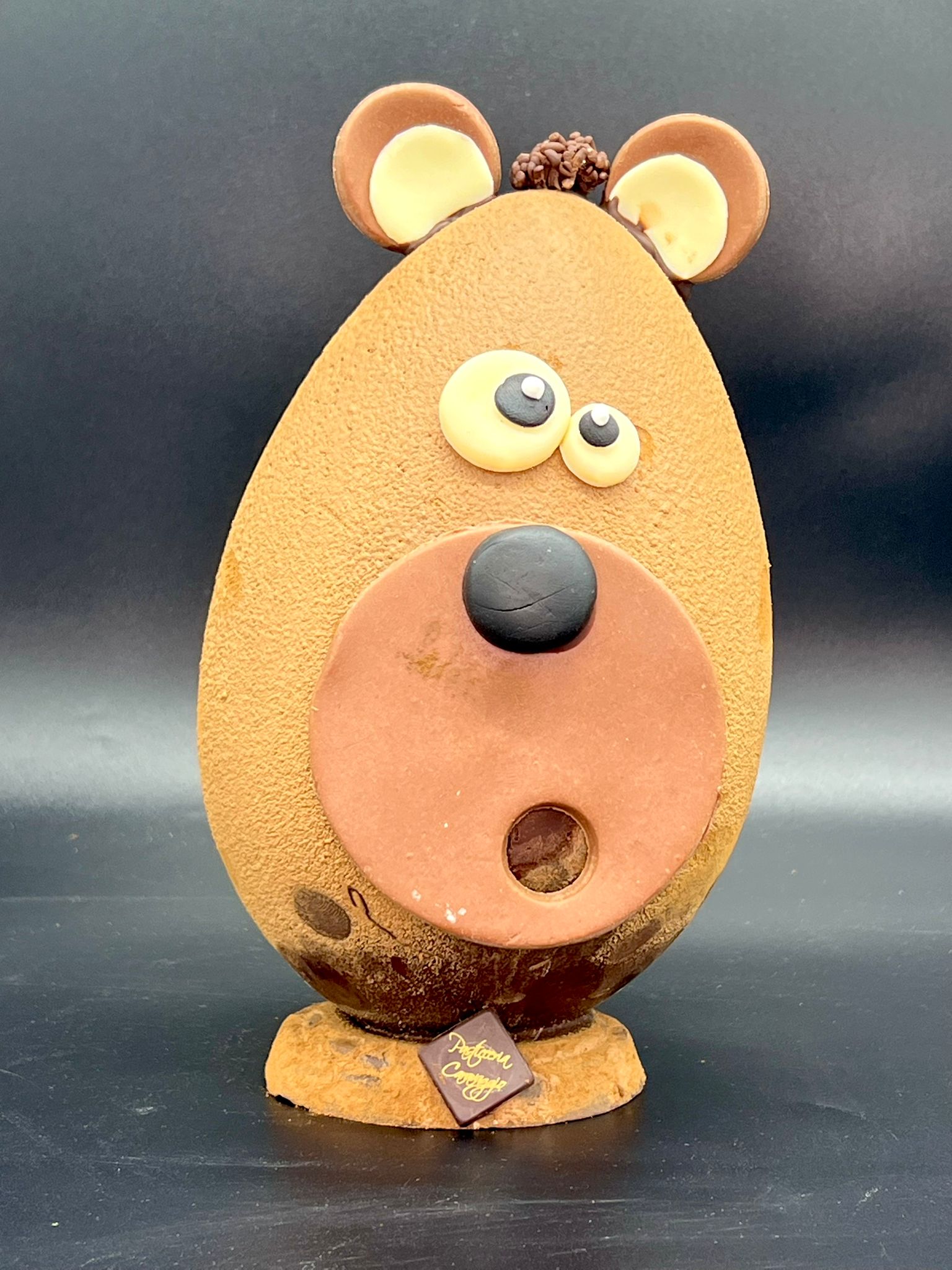 Uovo di cioccolato a forma di orsetto con occhioni e musetto goloso